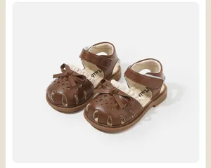 Elegant brown toddler girl princess sandals featuring hollow patterns and sweet bow detail