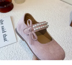 Detalle del zapato Mary Jane de ante rosa para niña con lazo y decoraciones de perlas