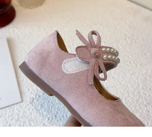 Primer plano detallado de un zapato de princesa rosa para niña con un lazo de perlas