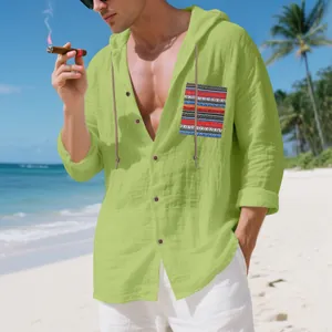 Detailed view of breathable men's green bohemian linen hooded shirt worn by model on beach