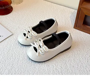 A detailed close-up of white girl's Mary Jane flat shoes with a cute bow decoration.