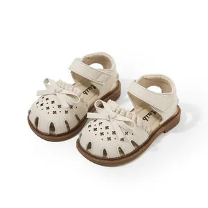Elegant girls' cream sandals with bow details and breathable laser-cut patterns