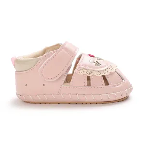 Profilo laterale di sandali primi passi rosa per neonata con eleganti ricami floreali e pizzo.