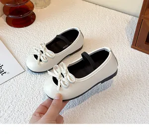 Close-up view of white girl's Mary Jane shoes featuring a cute bow detail and soft sole