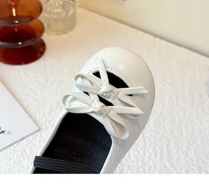 Close-up detail of white girls' leather Mary Jane shoes with lovely bow design