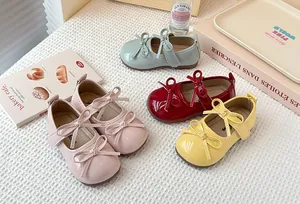 Detailed view of children's glossy Mary Jane shoes with double bow accents