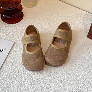 Khaki suede kids Mary Jane shoes with Velcro strap on a white textured background