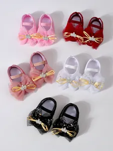 Détail de chaussures de bébé princesse en dentelle de plusieurs couleurs avec nœuds couronnes