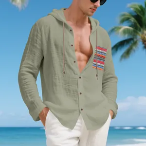 Men's olive green linen hooded shirt with ethnic striped pocket in a beach setting.