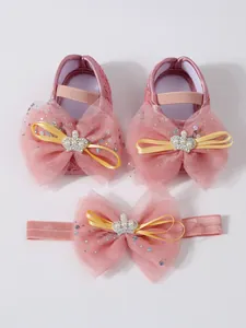 Détail de chaussures de princesse en dentelle pour bébé rose et bandeau assorti