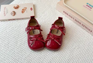 Close-up of red patent leather girls' Mary Jane shoes with double bow detail