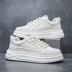 Close-up detail of white leather sneakers with chunky sole and geometric perforated pattern