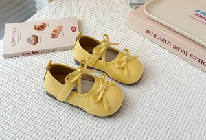 Detailed view of bright yellow patent leather Mary Jane shoes featuring elegant double bow knots