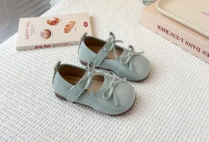 Close-up detail of mint green children's Mary Jane shoes featuring elegant double bow knots