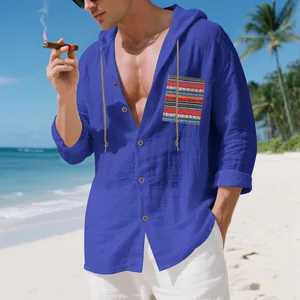 Blue men's bohemian linen hooded long sleeve shirt featuring a patterned pocket on the beach