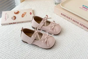 Detail view of pink patent leather Mary Jane shoes featuring double bow accents.