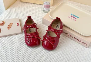 Detailed view of red patent leather Mary Jane shoes for girls with double bow accents
