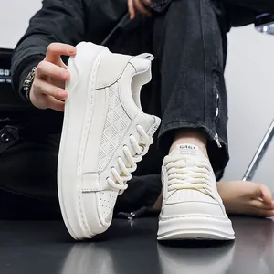 Close-up view of men's thick sole white leather sneakers with embossed patterns.