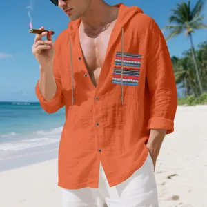 Detailed shot of a men's orange bohemian linen hooded shirt against a beach background