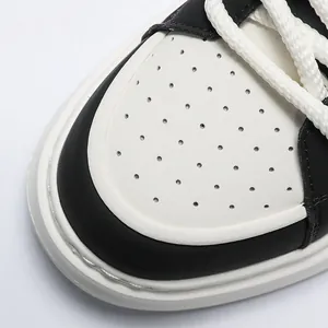 Close-up detail of breathable perforated leather toe on men's white platform sneaker