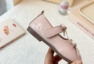 Close-up of pink patent leather Mary Jane shoe for girls with cute bow detail