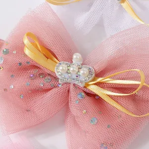 Gros plan de chaussures princesse pour bébé avec nœud en maille rose et couronne