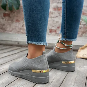 Detail view of women's grey flying woven platform sneakers worn on a wooden floor