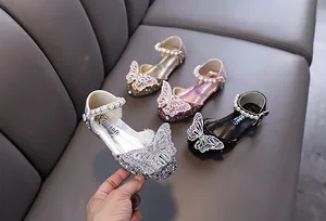 Exquisites Detail der Prinzessinnen-Mary-Janes für Mädchen mit Strass-Schmetterling und Perlen.