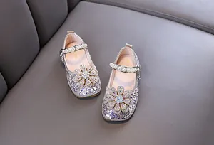 Nahaufnahme von glitzernden Mädchen-Prinzessinenschuhen mit Kristallblumen und Perlen