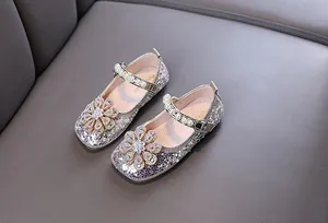 Detailansicht silberner glitzernder Mädchen-Prinzessin-Schuhe mit Strassblume und Perlenriemen.