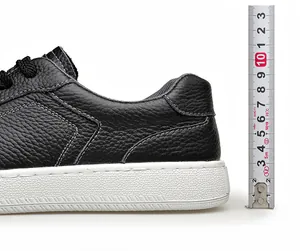 Gros plan du talon de chaussure en cuir noir avec mesure de la hauteur par un ruban