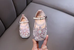 Nahaufnahme von rosa Mädchen-Prinzessinnenschuh mit funkelndem Strass und Perlen.