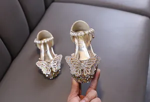Nahaufnahme goldene Mädchen Prinzessinnenschuhe mit Strass-Schmetterlingsdetail