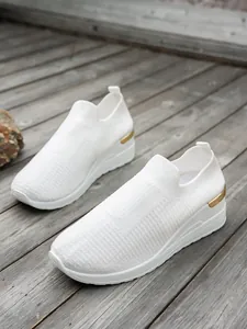 Stylish white fly-knit wedge sneakers for women featuring comfortable breathable mesh.