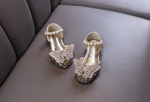 Detailansicht funkelnder goldener Mädchen-Prinzessinenschuhe mit Schmetterling