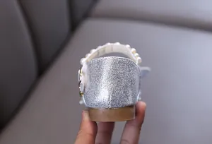 Detailansicht der silbernen Glitzer-Prinzessinenschuhe für Mädchen mit eleganten Perlenriemen