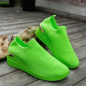 Detailed view of neon green fly-knit mesh and wedge sole on casual women's sneakers