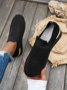 Detailed view of black breathable flying weave mesh slip-on sneakers with gold heel trim