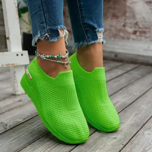 Detail view of vibrant lime green knitted wedge slip-on sneakers for women outdoor.