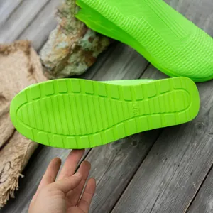 Detailed view of neon green knit sneakers showing anti-slip sole with size mark