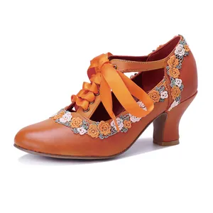 Close-up of vintage orange leather Mary Jane pump with delicate floral lace trim.