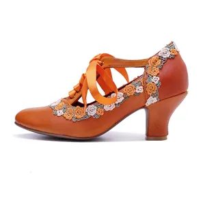 Side profile of vintage orange leather high heels featuring floral lace trim and ribbon ties
