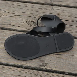 Detail shot showing the non-slip sole texture and size mark on black flat sandals.