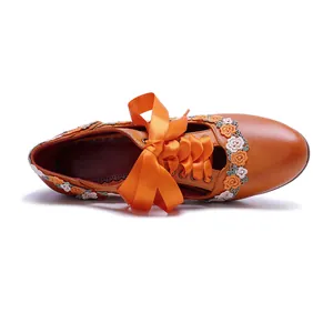 Top view of handmade leather Mary Jane heels with orange ribbon and floral lace decor