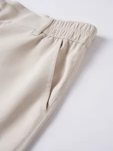 Detailansicht der beigen Freizeitshorts für Herren mit Tasche und elastischem Bund.