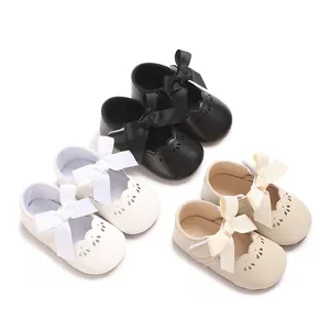 Vista detallada de zapatos de princesa para bebé con lazos elegantes y bordes festoneados.