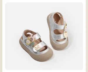 Close-up detail of silver baby girl walking sandals with cute rabbit decorations.