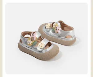 Macro detail of silver toddler girl closed-toe sandals featuring cute rabbit and button patches