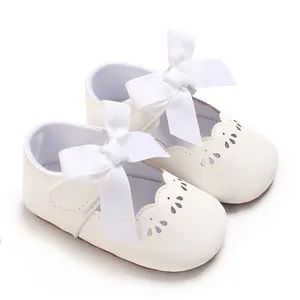 Vista detallada de zapatos de princesa para bebé con suela blanda y un gran lazo blanco