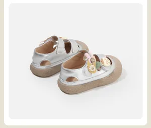 Detail view of silver baby girl sandals with cute 3D charms and thick gum sole